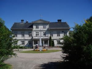 Una gran casa blanca con una cruz encima. en Åkerby Herrgård, en Nora