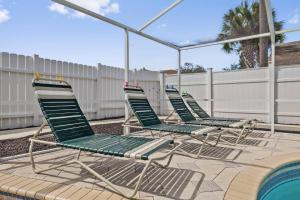 three lawn chairs sitting next to a swimming pool at Family Retreat with Heated Pool, Playground, Ping Pong Table in Jasmine Estates