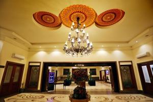 een grote lobby met een kroonluchter aan het plafond bij Hotel Meridien in Gujrānwāla