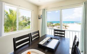 Un comedor con mesa y vista al mar. en Villa Turkuaz Entire Beach Front Villa, en Long Bay Hills