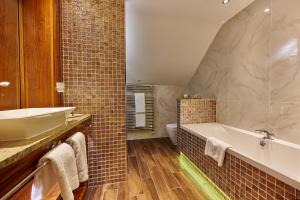 a bathroom with a tub and a sink and a toilet at Winteringham Fields in Winteringham