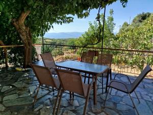 a table and chairs on a patio with a view at Το Αρχοντικό της Λενιώς in Taxiárkhis