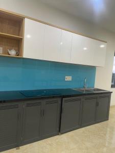 una cucina con mobili grigi e un lavandino di Moc Mien Seaside Homestay & Coffee Doc Let a Doc Let