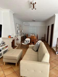 a living room with a white couch and a kitchen at Lotamar19 in Manta Rota