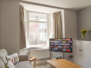 a living room with a couch and a window at Newstead Cottage in Weymouth