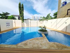 a large blue swimming pool in front of a white fence at HarborPoint Mactan in Mactan