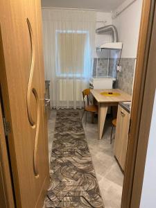 a room with a kitchen with a table and a door at Lemora Apartments 2 in Focşani