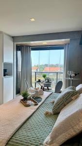 a bedroom with a large bed with a large window at (106) Studio Inesquecível em espaço Moderno in Vinhais +54 photos