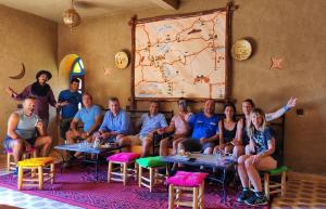 a group of people sitting at tables in a room at Porte De Sahara Ouzina in Ouzina