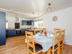 una cucina e una sala da pranzo con tavolo e sedie di Knocknahighle a Cromdale Altre 19 foto