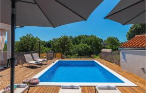 a swimming pool with an umbrella on a deck at Villa Unka in Potpićan