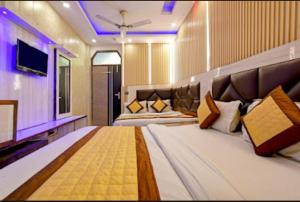 a large bedroom with two beds and a television at Rama Stay Pahar Ganj Delhi in New Delhi