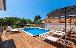 a swimming pool with two chairs and an umbrella at Villa Unka in Potpićan +41 photos