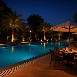 a table with an umbrella next to a swimming pool at night at The Vrindavan Manor - A Boutique Wellness Resort in Lap of Nature # By Elegance Group # in Vrindāvan