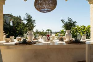 a table with plates of food and glasses on it at Villa San Vito Due in Ostuni