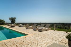 a patio with lounge chairs and a swimming pool at Villa San Vito Due in Ostuni +32 photos