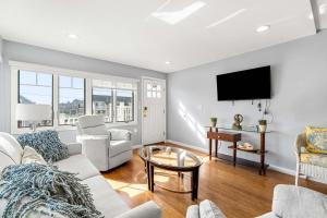 a living room with a couch and a tv at Serendipity Beach Retreat Nautical Retreat in Salisbury Beach +44 photos