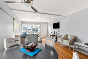 a living room with a table and a couch at Serendipity Beach Retreat Nautical Retreat in Salisbury Beach
