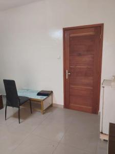 a room with a table and a wooden door at Al houda in Dakar