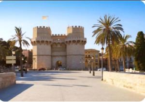 a building with palm trees in front of a street at URBAN LOFT VALENCIA in Valencia