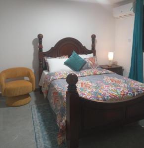 a bedroom with a bed and a chair at 4K-Suite in Kingston