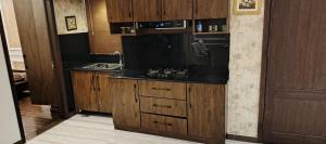una cucina con armadi in legno e piano di lavoro nero di 2 bed New Furnished Appartment at Lahore Prime Location a Lahore