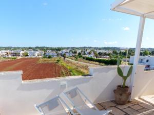 a balcony with two chairs and a view of a field at Mansarda - SUNSET in Torre Pali