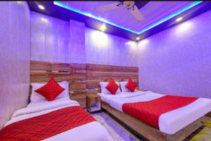 a bedroom with two beds with red pillows at Rama Stay Pahar Ganj Delhi in New Delhi +10 photos
