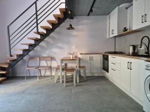 a kitchen with white cabinets and a table and chairs at apartments Lviv Vernygory 14 in Lviv +38 photos