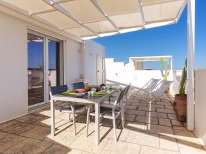 a dining room with a table and chairs on a patio at Mansarda - SUNSET in Torre Pali