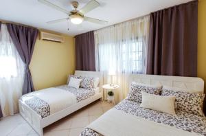 a bedroom with two beds and a ceiling fan at Condo very close beach in Punta Cana