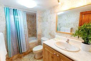 a bathroom with a sink and a toilet and a mirror at Condo very close beach in Punta Cana