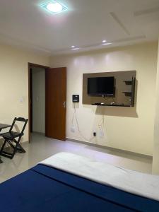 a living room with a tv on the wall at Apartamento inteiro in Itaperuna