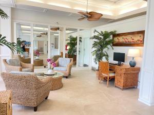 a living room with wicker furniture and a television at Maui Eldorado Condo A204 in Kaanapali