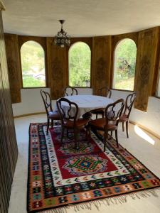 a dining room with a table and chairs on a rug at Conăcel între Vulcani in Beciu