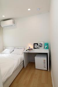 a bedroom with a white bed and a desk at Stay107 in Seoul