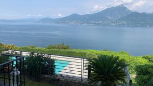 a swimming pool on a fence next to a body of water at Suite Incanto lago di Garda in Torri del Benaco +8 photos
