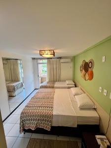 Un dormitorio con dos camas y una gran ventana. en FLAT EM BARREIRINHAS - Gran Solare Lencois, en Barreirinhas