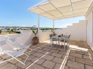 a patio with a table and chairs on a roof at Mansarda - SUNSET in Torre Pali
