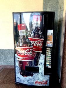 a cocacola machine with two coke bottles in it at Hotel La Union in Humanes de Madrid