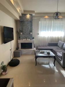 a living room with a couch and a fireplace at Sunny Garden in Koskinou