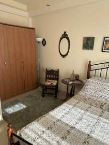 a bedroom with two beds and a table and a mirror at Sunny Garden in Koskinou +2 photos