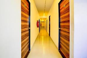a corridor with wooden doors in a house at Hotel O The Park View Rooms in Surat