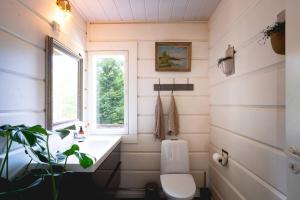 a bathroom with a toilet and a sink and a window at Stay North - Västerskog in Västerskog +39 photos