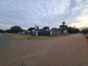eine leere Straße mit einem Haus am Straßenrand in der Unterkunft Queen Nanikie Guest House in Mooinooi
