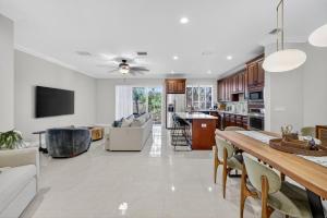 a kitchen and living room with a table and chairs at Daisy Elegance Townhouse Steps from The Beach in Pompano Beach