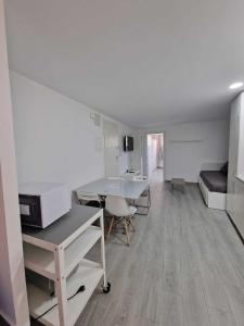 a white room with a desk and a bed at El Rincón de la tranquilidad Escapando de todo in Málaga +35 photos