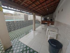 een patio met witte stoelen en een tafel en stoelen bij Piscina e mar in Angra dos Reis