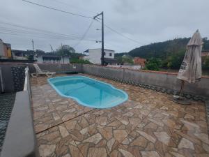 een klein blauw zwembad op een patio bij Piscina e mar in Angra dos Reis