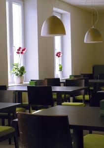 a dining room with tables and chairs and windows at Hotel Bahnhof Jestetten in Jestetten
